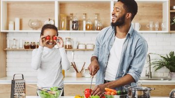 positive-dad-and-daughter-having-fun-on-kitchen